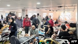 This handout photograph taken on December 16, 2023 and released on December 27 by the World Health Organization (WHO), shows Palestinians wounded waiting to be treated at al-Shifa Hospital in Gaza City.