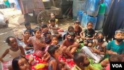 Younger children learn outside the bus that serves as a mobile school in New Delhi, India. (Anjana Pasricha/VOA)