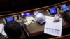 A face mask and protective gloves are seen on a lawmaker's desk during a session of Italy's Senate, the upper house of the country's parliament, on the spread of the coronavirus, in Rome, Italy, March 26, 2020.