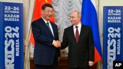 Chinese President Xi Jinping, left, and Russian President Vladimir Putin shake hands during their meeting on the sidelines of BRICS summit at Kazan Kremlin in Kazan, Russia, Oct. 22, 2024. 
