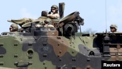 FILE - U.S. Marines from the 3rd Marine Expeditionary Brigade ride on an amphibious assault vehicle during assault exercises with Philippine marine troops in joint drills, Oct. 9, 2015.