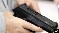 David Foley memegang pistol saat berbelanja di toko Spring Guns and Ammo, 4 Januari 2016, di Spring, Texas. (Foto: dok).