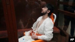 আদালতের কাঁচের খাঁচায় হুইল চেয়ারে বসে ১৯-বছর বয়স্ক মুহাম্মাদসবির ফাইযভ। ফটোঃ ২৪ মার্চ, ২০২৪।