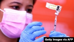 FILE - A nurse prepares a dose of the Pfizer COVID-19 vaccine at a clinic at Providence Wilmington Wellness and Activity Center, July 29, 2021, in Wilmington, Calif.
