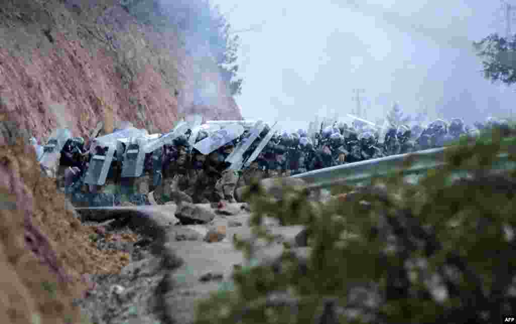 Police hold up their shields as they clash with protesters during a demonstration against the building of a mine in Artvin, northeastern Turkey, on February 17, 2016..