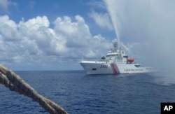 FILE - Chinese Coast Guard members approach Filipino fishermen as they confront each other off Scarborough Shoal in the South China Sea, Sept. 23, 2015.