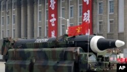 FILE - A missile that analysts believe could be the North Korean Hwasong-12 is paraded in North Korea on April 15, 2017. Japanese Defense Minister Yasukazu Hamada said a missile North Korea fired over Japan on Tuesday could have been a Hwasong-12.