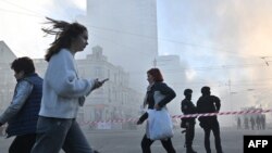 Local residents walk past police officers after a drone attack in Kyiv on Oct. 17, 2022, amid the Russian invasion of Ukraine.