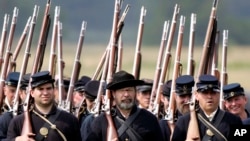 FILE — Re-enactors portraying the Union army's 20th Main, march during the 23rd Annual Gettysburg Civil War Heritage Days, in Gettysburg, Pa., June 25, 2005. Some historical battle re-enactors in New York are holding their musket fire because of worries over the state's new gun law.