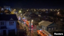 Firefighters work at a site of a plane crash into residential building in the city of Irkutsk, Russia, Oct. 23, 2022, in this still picture taken from a video. 