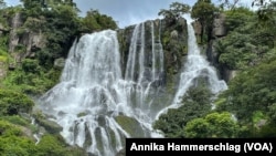 Visitors must jump between slippery rocks to reach the view from the top of Tabouna Falls in Guinea. It's the kind of tropical paradise that tourists would flock to, but its tourism sector has not yet been developed. 
