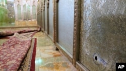 A bullet hole is seen in a shattered glass panel of the Shah Cheragh shrine in the southern city of Shiraz, Iran, Oct. 26, 2022, after gunmen attacked the Shiite holy site. (Iranian Students' News Agency, ISNA, via AP)