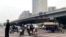 People ride scooters at an intersection near a bridge where social media videos earlier appeared to show smoke and protest banners in Beijing, Oct. 13, 2022. 