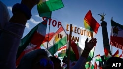 FILE - Protesters hold up a placard reading "Stop Execution in Iran" as they take part in a rally in support of the demonstrations in Iran, in front of the Victory Column in Berlin, Oct. 22, 2022.