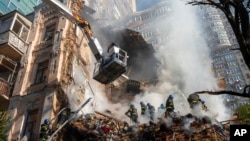 FILE - Firefighters work after a drone attack on buildings in Kyiv, Ukraine, Oct. 17, 2022.