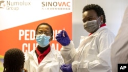 FILE - A health care worker holds a Sinovac vaccine before vaccinating a minor receives in Pretoria, South Africa, Sept. 10, 2021. 