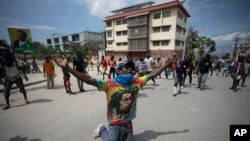 A demonstrator prays on his knees during a protest to demand the resignation of Prime Minister Ariel Henry in the Petion-Ville area of Port-au-Prince, Haiti, Oct. 3, 2022.
