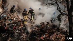 Ukrainian firefighters work on a destroyed building after a drone attack in Kyiv on Oct. 17, 2022, amid the Russian invasion of Ukraine.