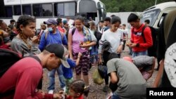 Migrantes rumbo a EEUU esperan para abordar un ómnibus con destino a la frontera con Guatemala, en las afueras de Tegucigalpa, la capital de Honduras, el 29 de septiembre de 2022.