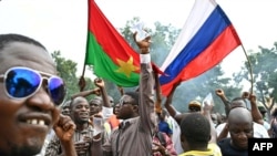 FILE - Supporters of Burkina Faso's new junta leader, Ibrahim Traore, hold national flags of Burkina Faso and Russia during a demonstration near the national radio and television headquarters in Ouagadougou, Oct. 6, 2022. Traore became president after the West African country's second coup in less than nine months.