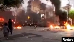 A person rides a motorcycle near a fire during a protest over the death of Mahsa Amini, in Javanrud, Iran, in this screengrab from a social media video released on Oct. 8, 2022, obtained by Reuters on Oct. 9, 2022.