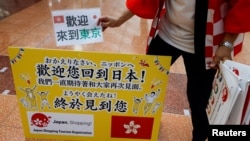 日本一家旅游公司的员工在羽田机场欢迎一个香港旅游团。（路透社2022年6月26日）