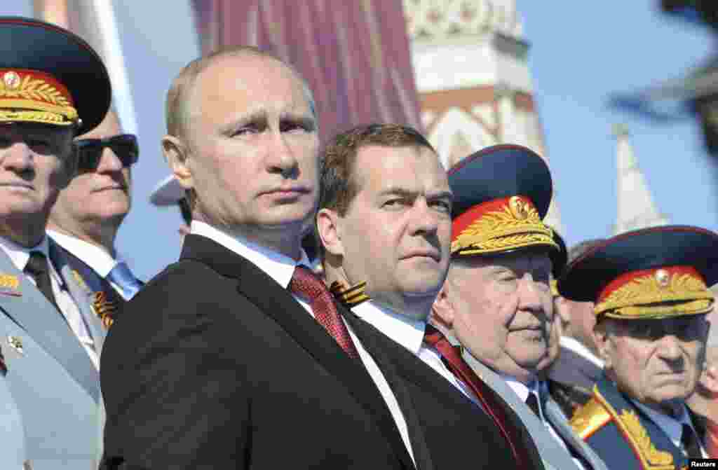 Russia's President Vladimir Putin (front L) and Prime Minister Dmitry Medvedev (C) watch the Victory Day parade in Moscow's Red Square.