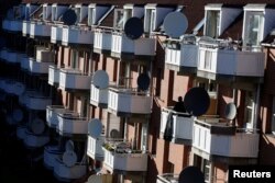 A woman stands on a terrace in Mjolnerparken, a housing estate on the Danish government's "Ghetto List," in Copenhagen, Denmark, May 8, 2018.