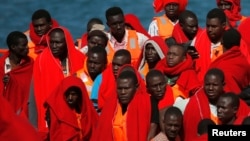 Migrants, part of a group intercepted aboard two dinghies off the coast in the Mediterranean Sea, stand on a rescue boat upon arrival at the port of Malaga, Spain, June 9, 2018.