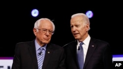 From left, Democratic presidential candidates, Sen. Bernie Sanders, I-Vt., former Vice President Joe Biden, talk before a Democratic presidential primary debate, Feb. 25, 2020.