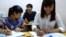 Student Pham Thi Trang (right) studies Japanese at a free language school set up by a street vendor, Hanoi, Vietnam, Aug. 7, 2014. (Marianne Brown/VOA)
