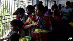 Evacuated Indian villagers watch the storm from a temporary shelter in Chatrapur, India, Oct. 12, 2013.