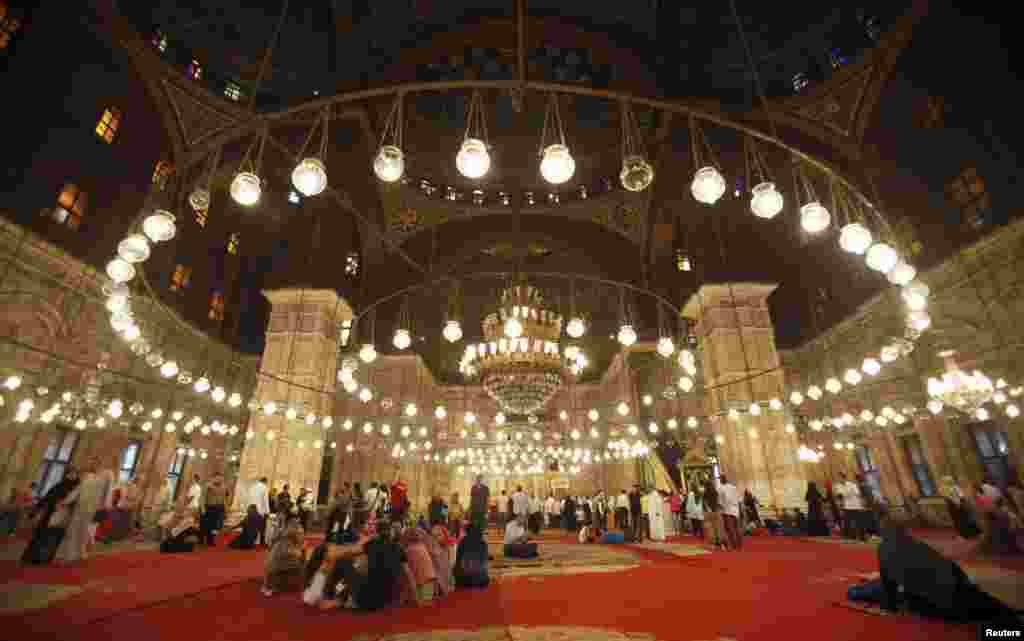 Jemaah mengaso setelah sholat Idul Fitri di masjid Mohammed Ali Pasha, dekat benteng Salah Addin Alayoubi di bagian kota tua Kairo, Minggu (19/8).