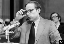 John Dean III, former White House aide in the Nixon Administration, adjusts his eyeglasses as he nears the end of reading his 245-page prepared statement before the Senate Watergate Committee in Washington, D.C., on June 25, 1973.