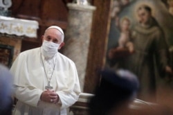 FILE - Pope Francis wears a face mask as he attends an inter-religious prayer service for peace in the Basilica of Santa Maria in Aracoeli, a church on top of Rome's Capitoline Hill, in Rome, October 20, 2020.