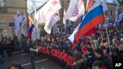 Demonstrators carry portraits of slain opposition leader Boris Nemtsov and a big poster reading "Killed for Freedom" during a march marking the one-year anniversary of his killing, in Moscow, Russia, Feb. 27, 2016.