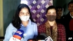 This photo taken from a frame grab from North East Live television channel shows journalists Samriddhi K. Sakunia and Swarna Jha speaking with the media in Nilambazar, in the northeastern Indian state of Assam, Nov. 14, 2021. (North East Live via AP)