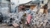 A soldier walks past rubble in the aftermath of an attack on the Afrik Hotel in Mogadishu, Somalia, Feb. 1, 2021. Al-Shabab claimed responsibility for the deadly assault. 