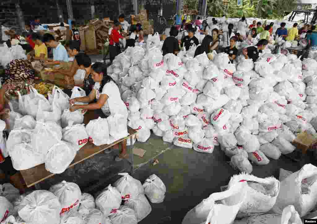 Para tenaga sukarela membungkus barang-barang bantuan untuk para korban Topan Haiyan di Departemen Kesejahteraan Sosial dan Pembangunan di Manila (8/11). (Reuters/Romeo Ranoco)