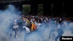 Demonstrators are seen amidst tear gas fired by security forces during an opposition rally in Caracas, Venezuela April 6, 2017. 
