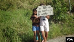 Children wait on roadsides hoping to get handouts from passing motorists, Cebu, Philippines, Nov. 15, 2013. (Steve Herman/VOA)