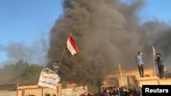 A headquarters building of Popular Mobilization Forces burns after being torched by demonstrators during ongoing anti-government protests, in Nassiriya, Iraq, Jan. 5, 2020.