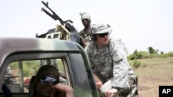 Malian troops and their U.S. Special Forces instructor await the start of a live-fire drill in Kita, Mali, during a joint training exercise with a unit of elite Malian troops, May 10, 2010.