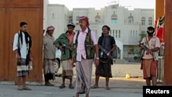 FILE - Armed men loyal to Yemen President Abd-Rabbu Mansour Hadi stand guard outside a local authority compound after taking it over in Yemen's southern port city of Aden, Feb. 16, 2015.