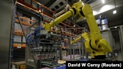 Robotic arms sort and load yogurts onto pallets at a distribution centre near Prague, Czech Republic, February 17, 2020. (REUTERS/David W Cerny)