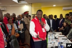 FILE - Presidential candidate Uhuru Kenyatta, address his supporters after receiving a clearance certificate from Chairman of Independent Electoral and Boundaries Commission for the presidential race, at Kenyatta International Conference Centre in Nairobi.