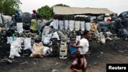 FILE - Children walk past charcoal sellers in Kitwe, Zambia, Jan. 17, 2015. With drought harming crop yields across southern Africa, officials say food insecurity and the struggling economy are pushing more people to cut down trees to produce charcoal for sale.