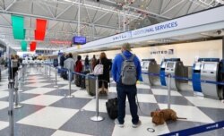 People wait at O'Hare International Airport in Chicago, Nov. 20, 2020. With the coronavirus surging, top U.S. public health officials urged Americans not to travel for Thanksgiving and not to spend the holiday with those outside their households.