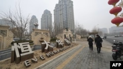 People walk past an Evergrande Group residential complex called Evergrande Palace in Beijing on Jan. 30, 2024.