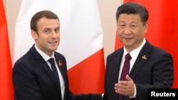 Le président français Emmanuel Macron échange une poignée de mains avec son homologue chinois Xi Jinping en marge du sommet de G20 à Hambourg, Allemagne, 8 juillet 2017.